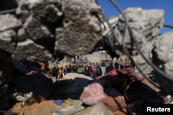 Palestinci stoje na mjestu izraelskog napada na kuću, usred sukoba između Izraela i militantne grupe Hamas, u Rafi, na jugu Pojasa Gaze, 19. decembra