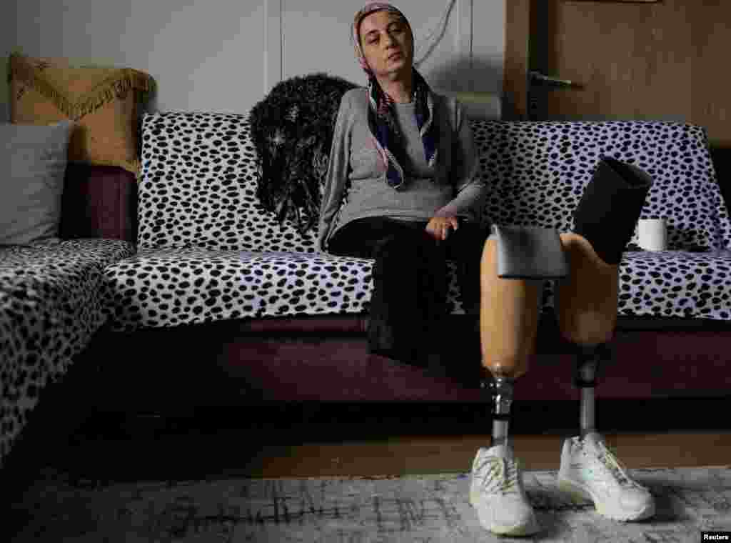 Gulcan Yilmaz, 47 vjeçe, e cila u shpëtua nga rrënojat e ndërtesës tetëkatëshe Sendag pesë ditë pas tërmetit të vitit të kaluar dhe humbi këmbët dhe krahun e djathtë, qëndron ulur në shtëpinë e saj të improvizuar në lagjen Ekinci të Antakias, në provincën Hataj, Turqi, janar 2024.