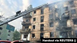 Mentőcsapat az orosz rakétacsapásban súlyosan megrongálódott lakóháznál Krivij Rihben 2023. június 13-án