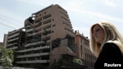Një grua qëndron pranë ndërtesës së Shtabit të Përgjithshëm të ushtrisë jugosllave, e bombarduar nga NATO-ja më 1999, në Beograd, 15 qershor 2006.