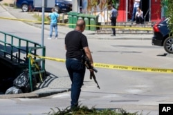 Un ofițer de poliție ține o pușcă în timp ce Bosnia căuta un bărbat care și-a împușcat și și-a ucis soția în timp ce transmitea în direct pe Instagram, în august 2023.