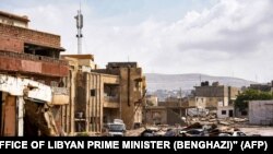 Uništena vozila i zgrade na ulicama Derne, grada 290 kilometara istočno od Bengazija.