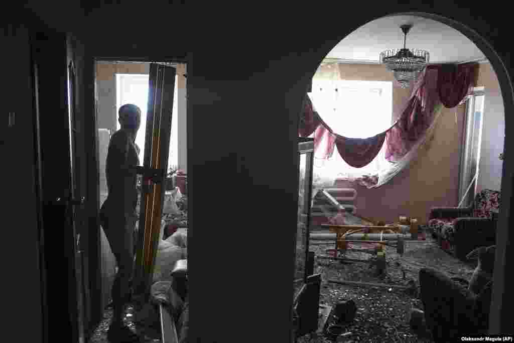 Чоловік намагається відтягнути вибиті вибухом двері його помешкання. Первомайський, 4 липня 2023 року Кремль постійно заперечує, попри численні факти і докази, що російська армія цілеспрямовано атакує цивільне населення України. Так само, як Росія заперечує, що спричинила руйнування Каховської ГЕС або створила небезпечну ситуацію, захопивши у перші дні масштабного вторгнення ЗАЕС.