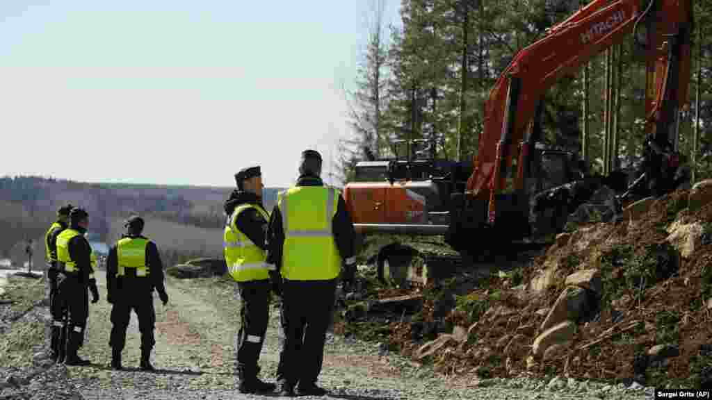 Egy kotrógép dolgozik a finn határőrök mellett a pelkolai határ közelében április 14-én. Az új határkerítés a tervek szerint 2026-ban készül el