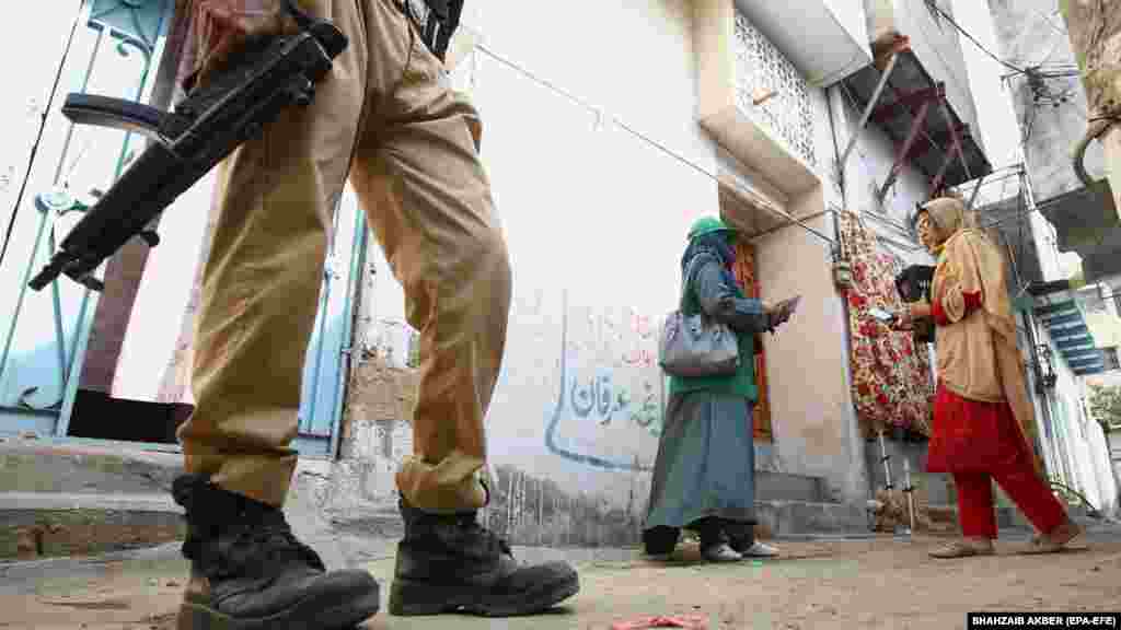 Radnica pakistanskog biroa za statistiku, u pratnji naoružanog čuvara, prikuplja podatke za digitalni popis stanovništva u Karačiju 1. marta.