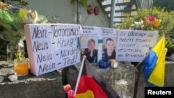 Окуя болгон жерге гүлдөр жана шамдар коюлуп, тургундар аза күтүүдө. 29-апрель, 2024-жыл. Мурнау шаары.