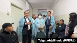 Саламаттык сактоо министри Алымкадыр Бейшеналиев жана билим берүү министри Сузактагы ооруканага барган учур. 