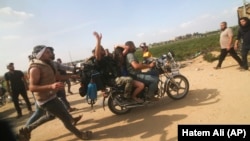 گروهی از غیرنظامیان فلسطینی روز هفتم اکتبر ۲۰۲۳ با ربودن یک گروگان اسرائیلی از کیبوتص «کفر عزه» در نزدیکی نوار غزه، او را به این باریکه می‌برند