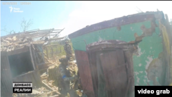 Боєць полку «Цунамі» кидає гранату у підвал під час зачистки будинку у Кліщіївці