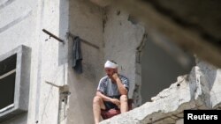 Sérült palesztin férfi nézi az utcát Rafahban az izraeli légicsapásban megrongálódott lakásából 2024. április 29-én
