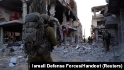 Izraelski vojnici na severu Pojasa Gaze hodaju između razrušenih zgrada, 7. novembar 2023.