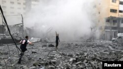 Palestinci stoje među ruševinama nakon izraelskih napada na stambenu zgradu u Gazi, 9. oktobra 2023.