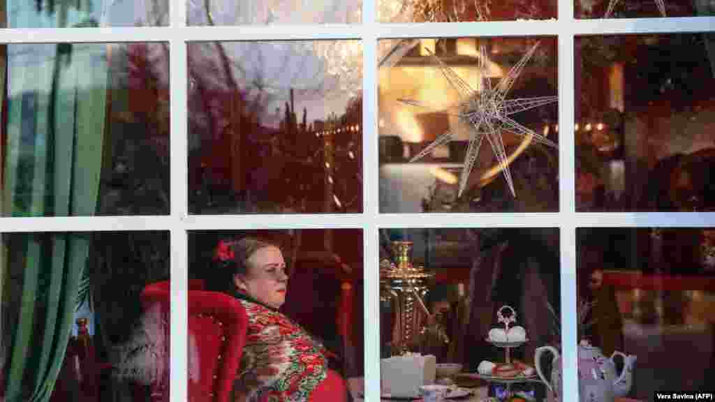 Žena gleda sa prozora paviljona na ruskom Novogodišnjem i Božićnom sajmu u centru Moskve.