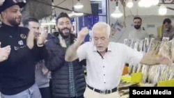 عکس از رقص صادق بنا متجدد، معروف به «صادق بوقی»، در بازار ماهی‌فروشان رشت