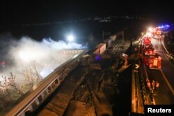 Vatrogasci na mjestu nesreće, gdje su se sudarila dva voza, u blizini grada Larisse, Grčka, 1. marta 2023.
