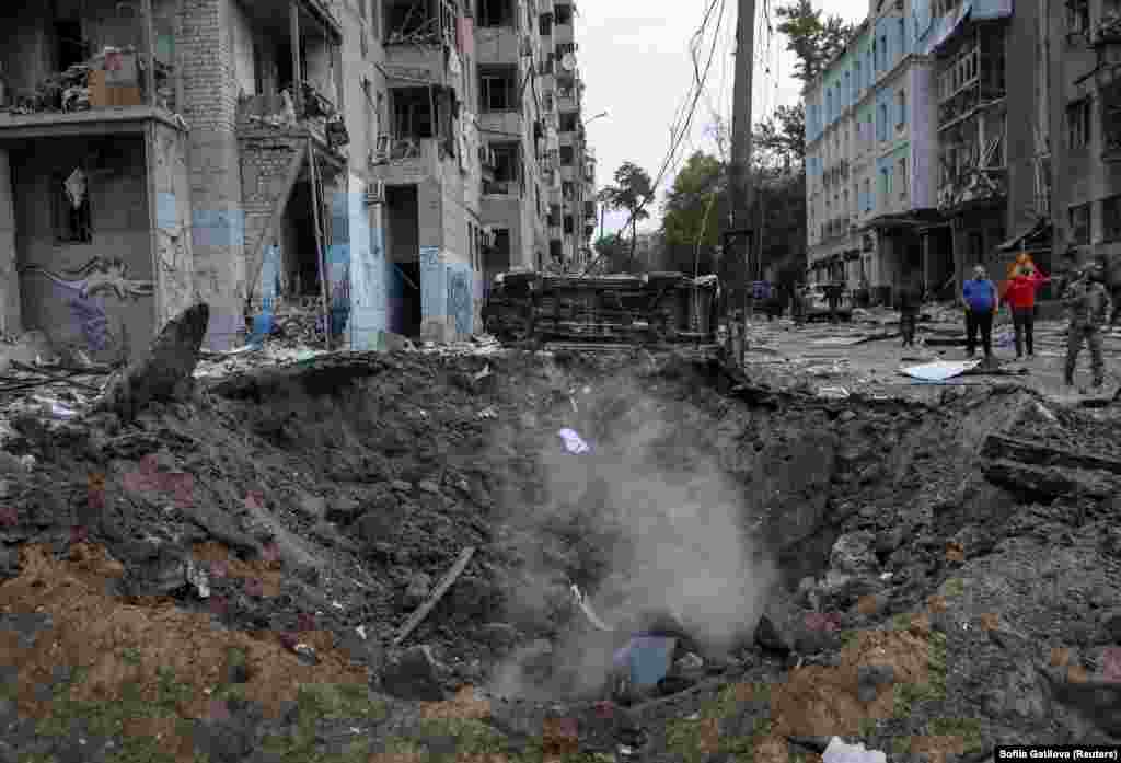 O mașină, răsturnată de suflul exploziei, în vecinătatea craterului apărut în urma atacului.