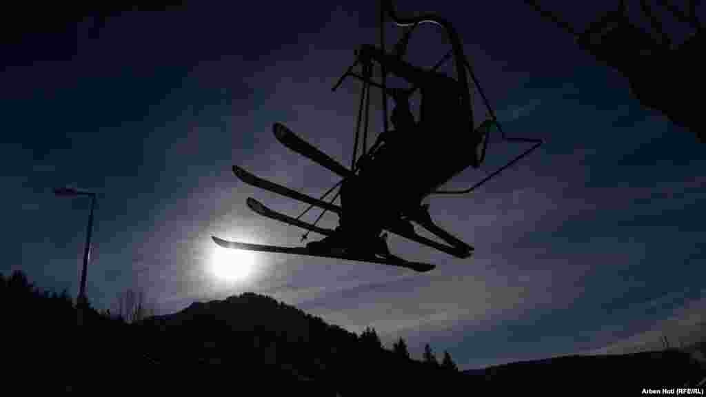 Disa vizitorë në teleferik një perëndim dielli.