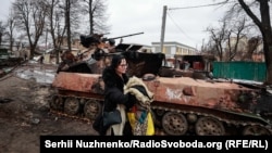 Olha, banore e Buçës, thotë për Radion Evropa e Lirë: “Kur babai im ndërtoi shtëpinë tonë, ai bëri një bodrum poshtë dhe na tha: Nëse ndodh ndonjë gjë, ky është strehimi juaj nga bombat”. “Kur ndodhi [pushtimi], jashtë pamë tanke duke qëlluar në oborrin tonë. Ne nxituam tek ai bodrum”, kujton ajo.