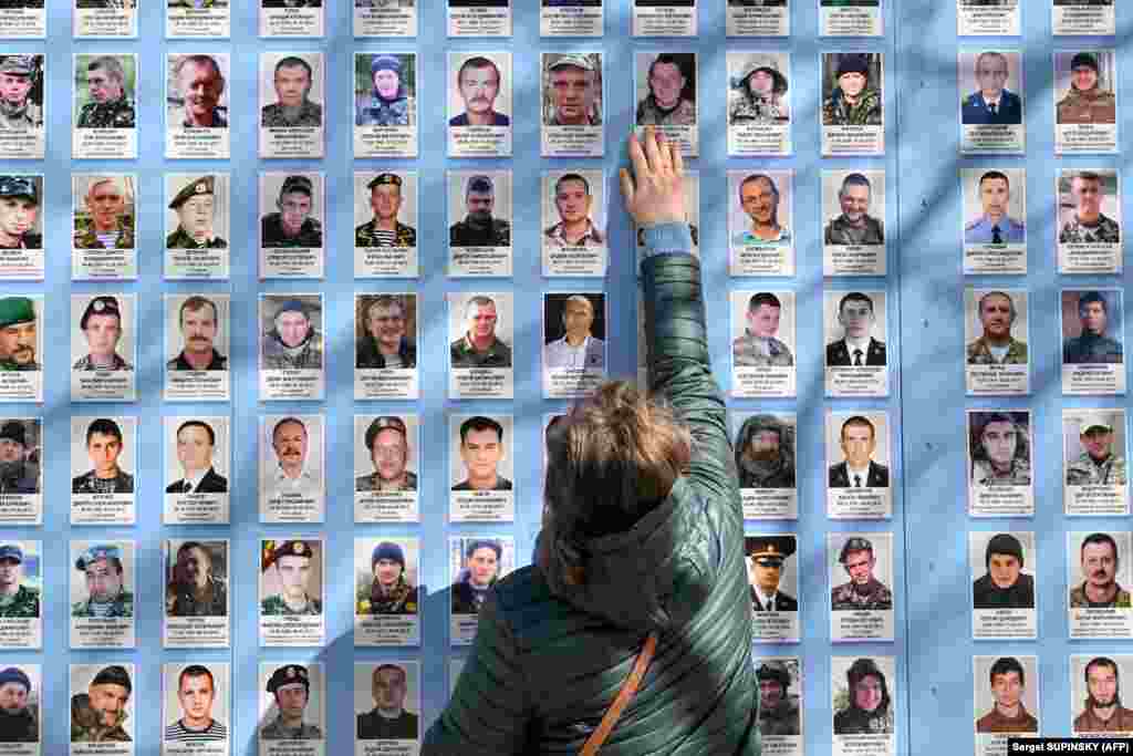 Žena dodiruje fotografiju svog sina, koji je poginuo boreći se za Ukrajinu, kod Zida sjećanja tokom ceremonije obilježavanja Dana volontera u Kijevu 14. marta. &nbsp; Taj datum je 2017. godine ustanovio ukrajinski parlament, Vrhovna rada, u čast hrabrosti i herojstva branilaca nezavisnosti, suvereniteta i teritorijalnog integriteta Ukrajine.