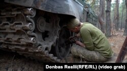 Танк готують до зими – боєць змащує підшипники солідолом