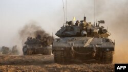 Израелски танкове се движат близо до границата с Ивицата Газа в неделя, след като сраженията между Израел и ислямистката палестинска групировка Хамас бяха подновени в петък.