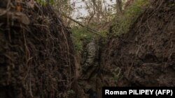 Український військовослужбовець 65-ї механізованої бригади йде траншеєю, збудовану російськими військами, біля прифронтового села Роботине Запорізької області, 1 жовтня 2023 року