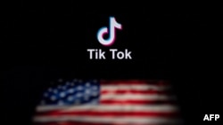 Logoja e aplikacionit TikTok (lart) dhe flamuri amerikan (poshtë) shihen në ekranet e dy laptopëve në Pekin. Fotografi ilustruese.