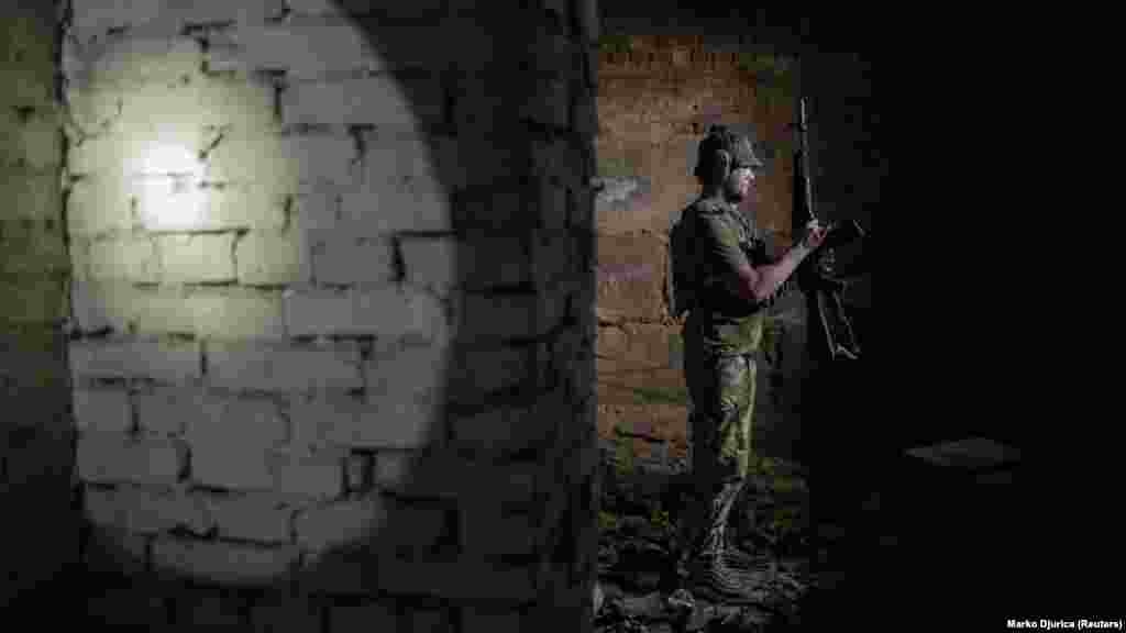 A Szics egyik tagja, Artem a fegyverét ellenőrzi a Harkiv melletti előretolt bázison