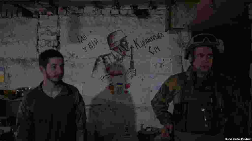 A zászlóalj tagjai egy katonát ábrázoló rajz mellett. A felirat fordítása: &bdquo;Megy a csatába Kárpáti Szics&rdquo;. A Kanada becenevű Denisz Poliscsuk azt mondja, hogy bár tart az orosz fogságtól, az nem fogja megállítani.&nbsp;&bdquo;Ez nem fogja megváltoztatni a döntésemet. Ez mindenképpen olyan dolog, amit szem előtt kell tartani és mérlegelni, de ugyanakkor ez háború. Mindannyian tudjuk, hogy milyen következményei lehetnek annak, hogy itt vagyunk, és mindannyian megbékéltünk ezzel&rdquo;