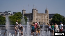 Njerëzit duke u freskuar nëpër fontana në Londër.