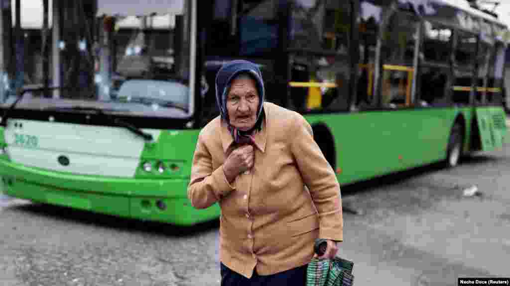 Ukrajinka prolazi pored autobusa oštećenog u ruskom napadu na Harkiv, 21. juli.