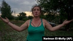 A 43 éves Tetyana Pasko egy rakétatámadásban megsérült háza előtt a kelet-ukrajnai Pokrovszkban 2022. július 16-án