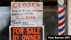 Написи «Продається власником» та «Закрито через вірус» на дверях магазину в місті Ґросс-Пойнт-Вуд у штаті Мічіґан, США, квітень 2020 року