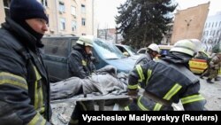 Украина, Харьков. Куткаруучулар ракеталык аткылоодон жаракат алган кишини көтөрүп баратышат. 1-март, 2022-жыл.