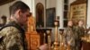Украински војници се молат во православна црква за време на Велигден во Слованск, во близина на линијата на фронтот во регионот Источен Донецк, на 24 април.