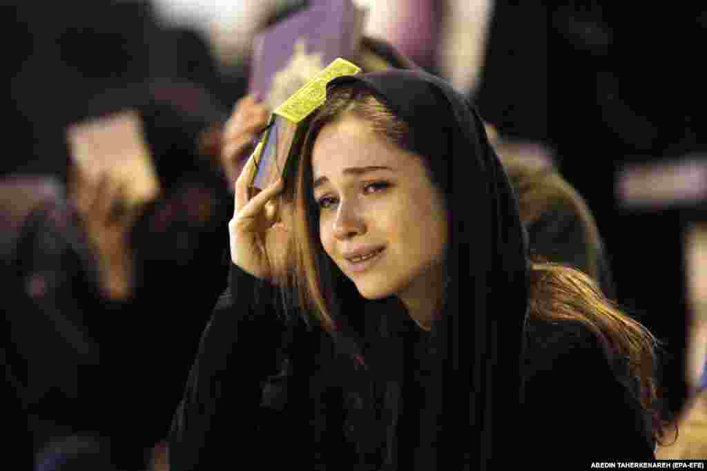 Një grua myslimane shiite lutet dhe vendos Kuranin në kokë, gjatë një ceremonie fetare në xhaminë Mosalah në Teheran.