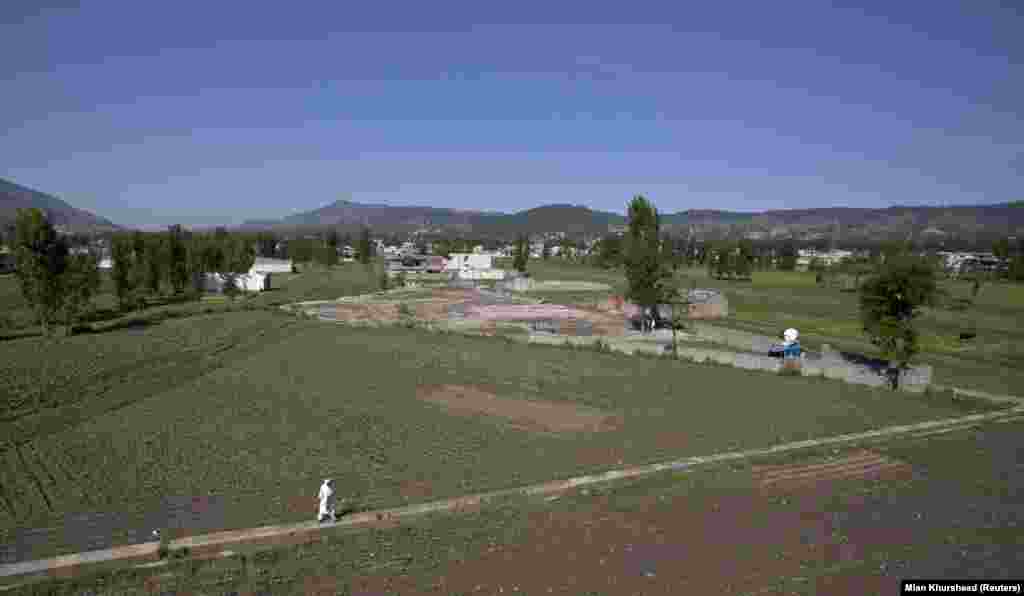 Një burrë ecën më 2012 afër vendit ku dikur ndodhej kompleksi i Bin Ladenit. Imazhet satelitore nga viti 2021 shfaqin plot shtëpi të reja të ndërtuara në lagje që nga viti 2011, por vendi ku ndodhej kompleksi mbetet bosh, dhe shfrytëzohet nga vendësit për të luajtur kriket.