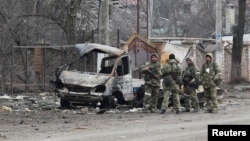 Az oroszokat támogató erők nemzetük jelzése nélküli egyenruhában a donyecki régió Volnovaga városában 2022. március 15-én