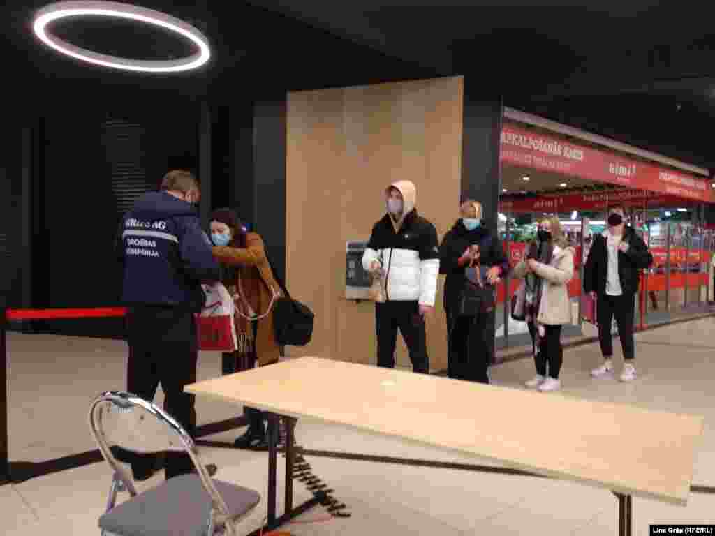 Agenții de securitate de la intrarea într-un mall din Riga spun că majoritatea respecta noile reglementări.