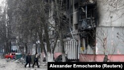 Local residents walk near a residential building damaged by Russian shelling in the besieged southern port city of Mariupol on March 18.