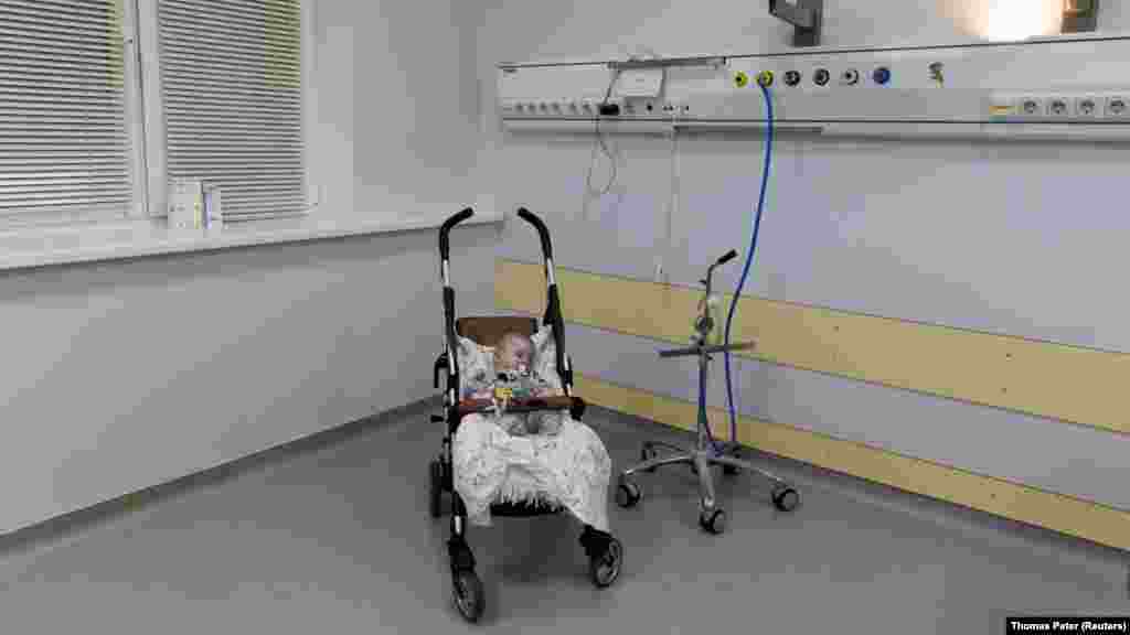 Egy öt hónapos, árván maradt csecsemő alszik babakocsijában a Kijevi Szívklinikán, miután kimenekítették az ostrom alatt álló Szumiból 2022. március 20-án