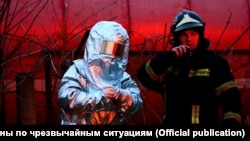 Украинанын куткаруу жана өрт өчүрүү кызматынын өкүлдөрү Львовдогу орус күчтөрү сокку урган кара май кампасындагы өрттү өчүрүүгө аракет кылып жатат. 26-март, 2022-жыл. 