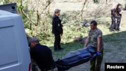 Forenzičari stavljaju tijelo djevojčice ubijene tokom ruskog raketnog udara u kombi u Kijevu 1. juna.