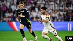 Njemački vezista Ilkay Gundogan (desno) i veznjak Škotske Scott McTominay u duelu tokom utakmice otvaranja EURO 2024 u Minhenu, Njemačka, 14. juna 2024.
