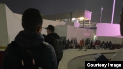 Мексика менен АКШнын чек арасынан өтүп жаткан адамдар.