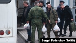 Mozgósított férfiak szállnak fel a buszra a moszkvai Roman Viktyuk színháznál felállított ideiglenes mozgósítási állomás előtt szeptember végén