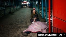 Žena kleči pored tijela mrtvog muža nakon ruskog granatiranja ukrajinskog grada Hersona 24. decembar