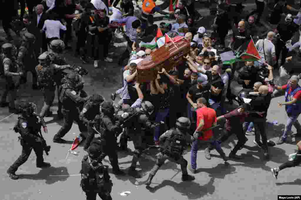 Poliția israeliană intervine violent contra unei mulțimi care cară sicriul jurnalistei Al Jazeera Shireen Abu Akleh, la înmormântarea ei în Ierusalimul de est, 13 mai 2022. Abu Akleh, jurnalistă americană de origine palestiniană care a scris despre conflictul din Orientul Mijlociu mai mult de 25 de ani, fusese împușcată mortal două zile mai devreme într-un raid al armatei israeliene&nbsp;în orașul Jenin din Cisiordania.&nbsp;&nbsp;(AP Photo/Maya Levin)