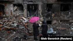 Două vecine stau de vorbă în fața unui bloc de locuințe din orașul Vîșhorod, din apropiere de Kiev (arhivă).