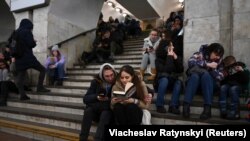 Бомбалоодон жашынып Киевдин метросунда отурган шаар тургундары. Украина. (Сүрөттүн макаладагы каармандарга тиешеси жок).